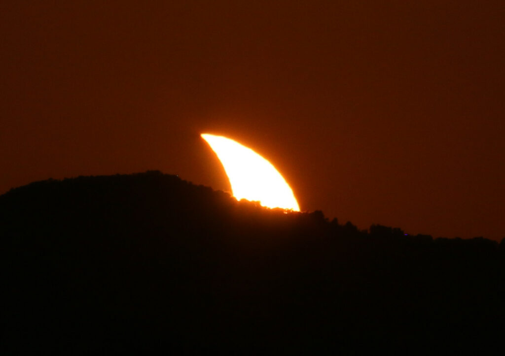 Éclipse du 12 août 2026. Le Soleil toujours éclipsé partiellement se couche. C'est donc un croissant solaire qui se cache derrière l'horizon.